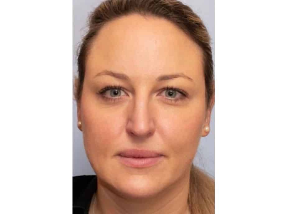 Professional headshot of a woman with pulled-back hair, pearl earrings, neutral expression